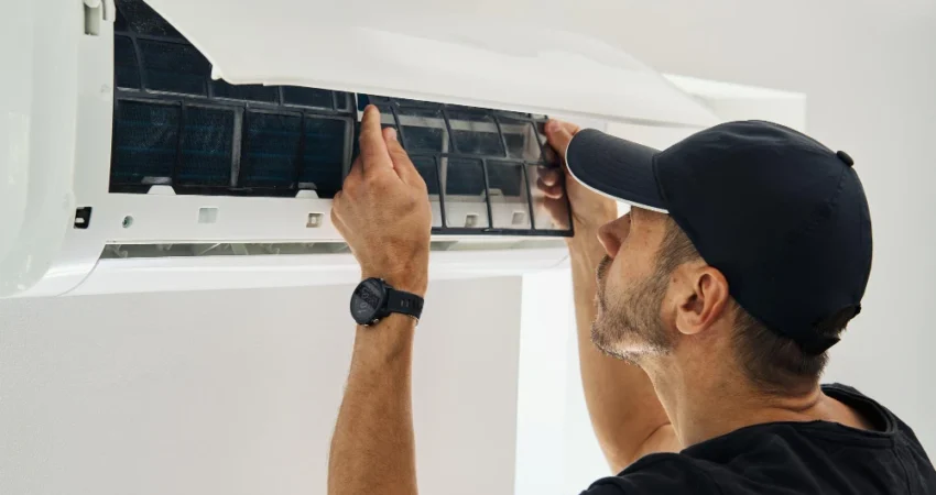 HVAC technician inspecting AC unit filters for a home maintenance contract in Abu Dhabi